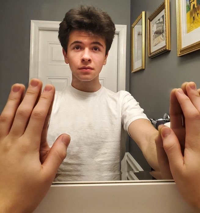 foto de un chico tocando un espejo con ambas manos