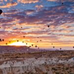 Un paisaje nocturno lleno de globos aerostáticos.