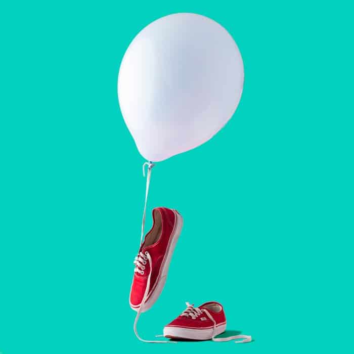 foto de zapatillas rojas con un globo blanco y un fondo turquesa
