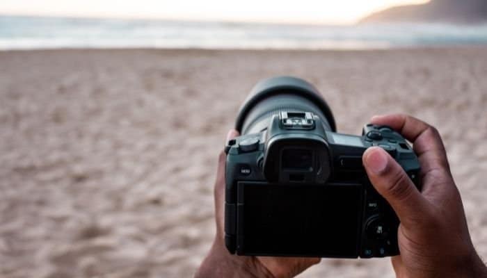 persona con cámara réflex digital en la playa
