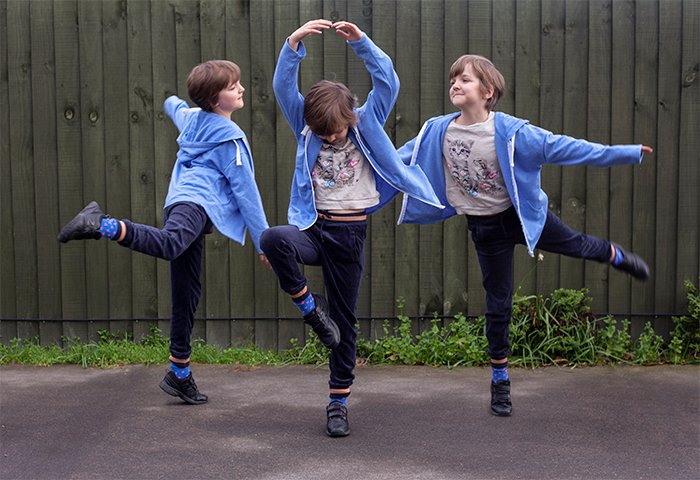 Ejemplo de fotografía de multiplicidad de tres de la misma niña bailando al aire libre