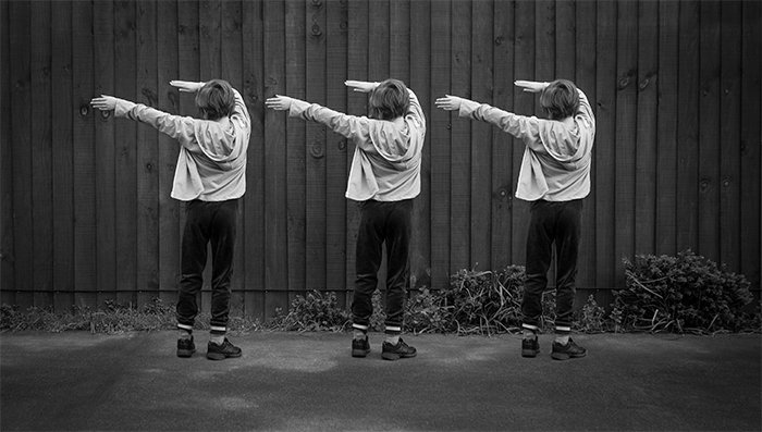 Un ejemplo de fotografía de multiplicidad en blanco y negro de tres de la misma niña bailando al aire libre