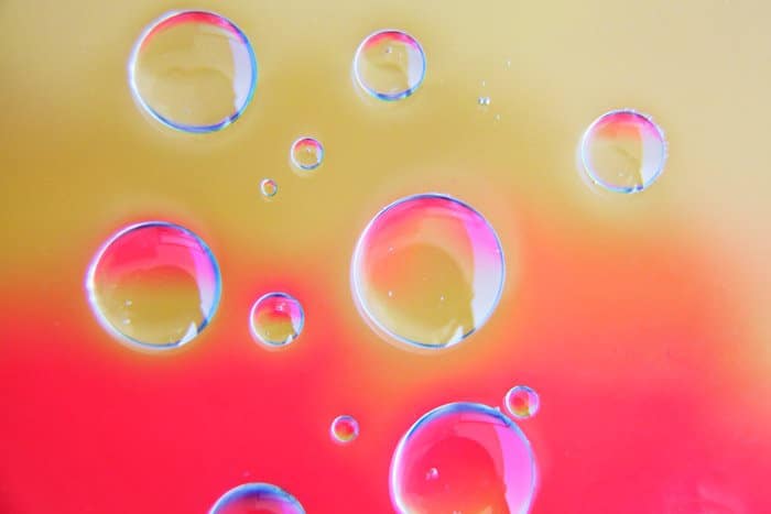 fondo rosa brillante y arena con 13 burbujas transparentes creadas a partir de fotografías con aceite y agua