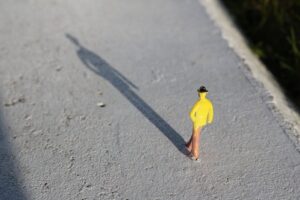 Una figura de juguete amarilla sobre una superficie de hormigón.