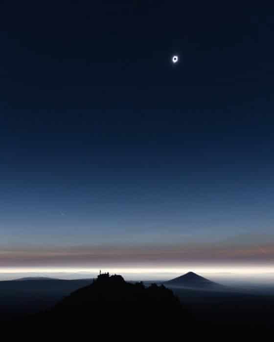 foto del eclipse solar sobre un paisaje de noche