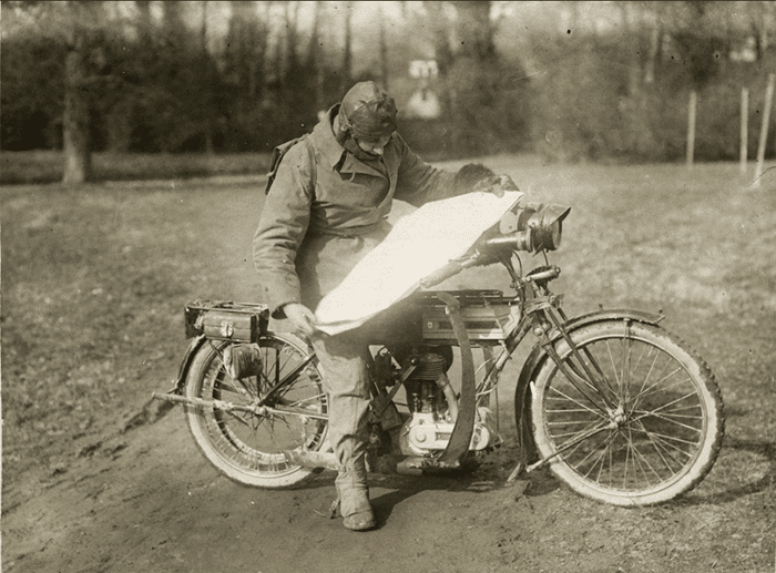 Vieja foto en tonos sepia de un hombre en una moto