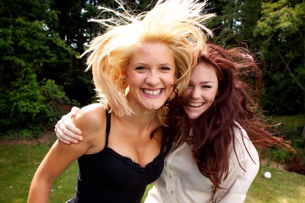 Foto de dos mujeres jóvenes en movimiento con el pelo al viento