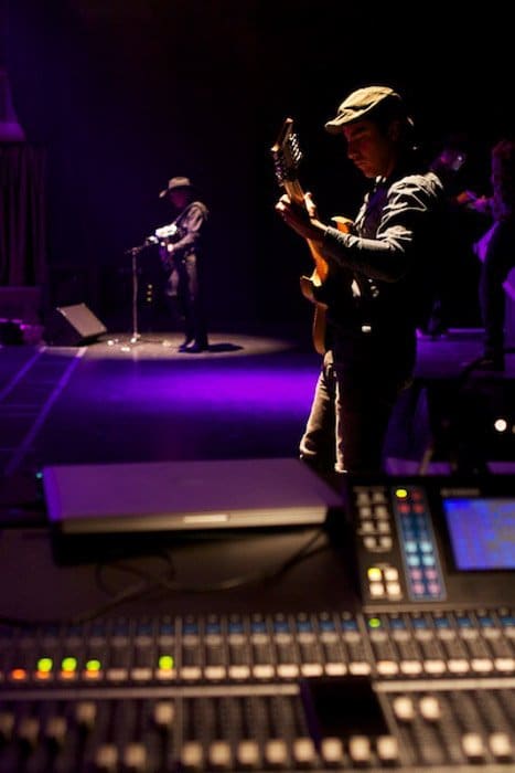 Foto de dos personas en un escenario tocando guitarras.