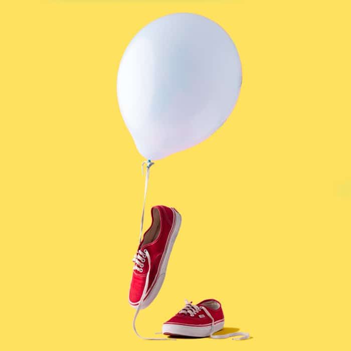 foto de zapatillas rojas con un globo blanco y fondo amarillo