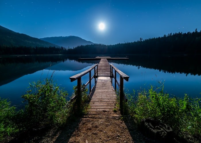 Fotografía nocturna serena de montañas y lago.