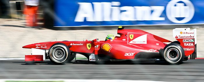 Un coche de carreras rojo en el GP de Italia número 82 en Monza con desenfoque de movimiento creativo