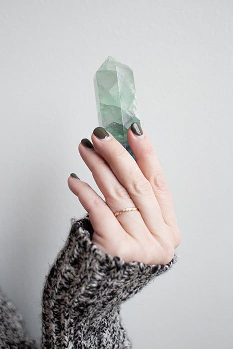 genial fotografía de uñas de una modelo femenina con uñas pintadas sosteniendo una gema preciosa