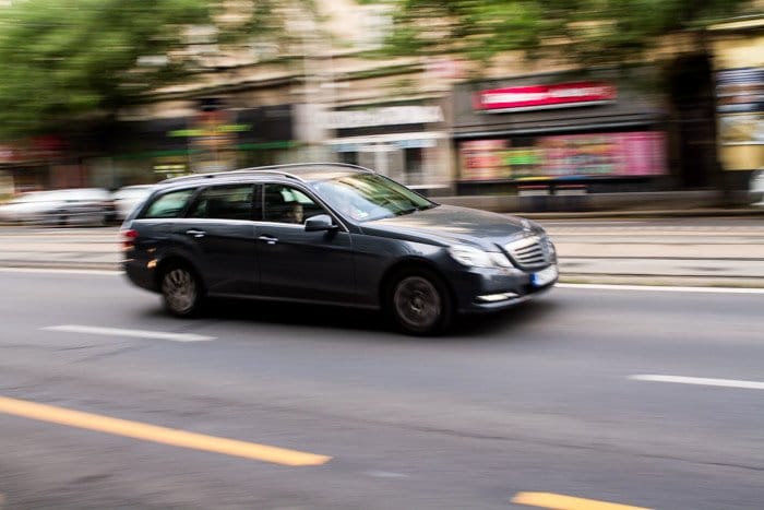 Una foto borrosa de un auto gris conduciendo por la calle
