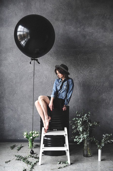 Una modelo femenina posando junto a un gran globo negro en un estudio de fotografía: pasantías de fotografía